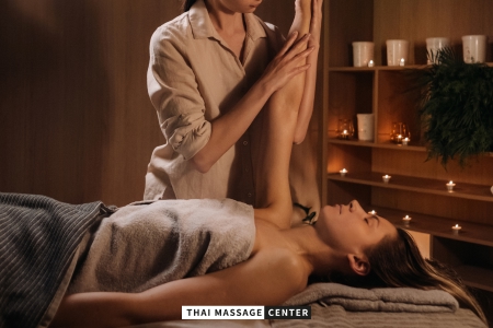 Professional Thai therapist using assisted stretching techniques during a traditional Thai massage treatment